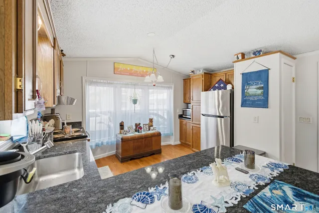 a living room with furniture kitchen view and a large window