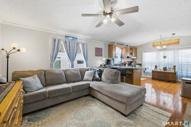 a living room with furniture kitchen view and a chandelier