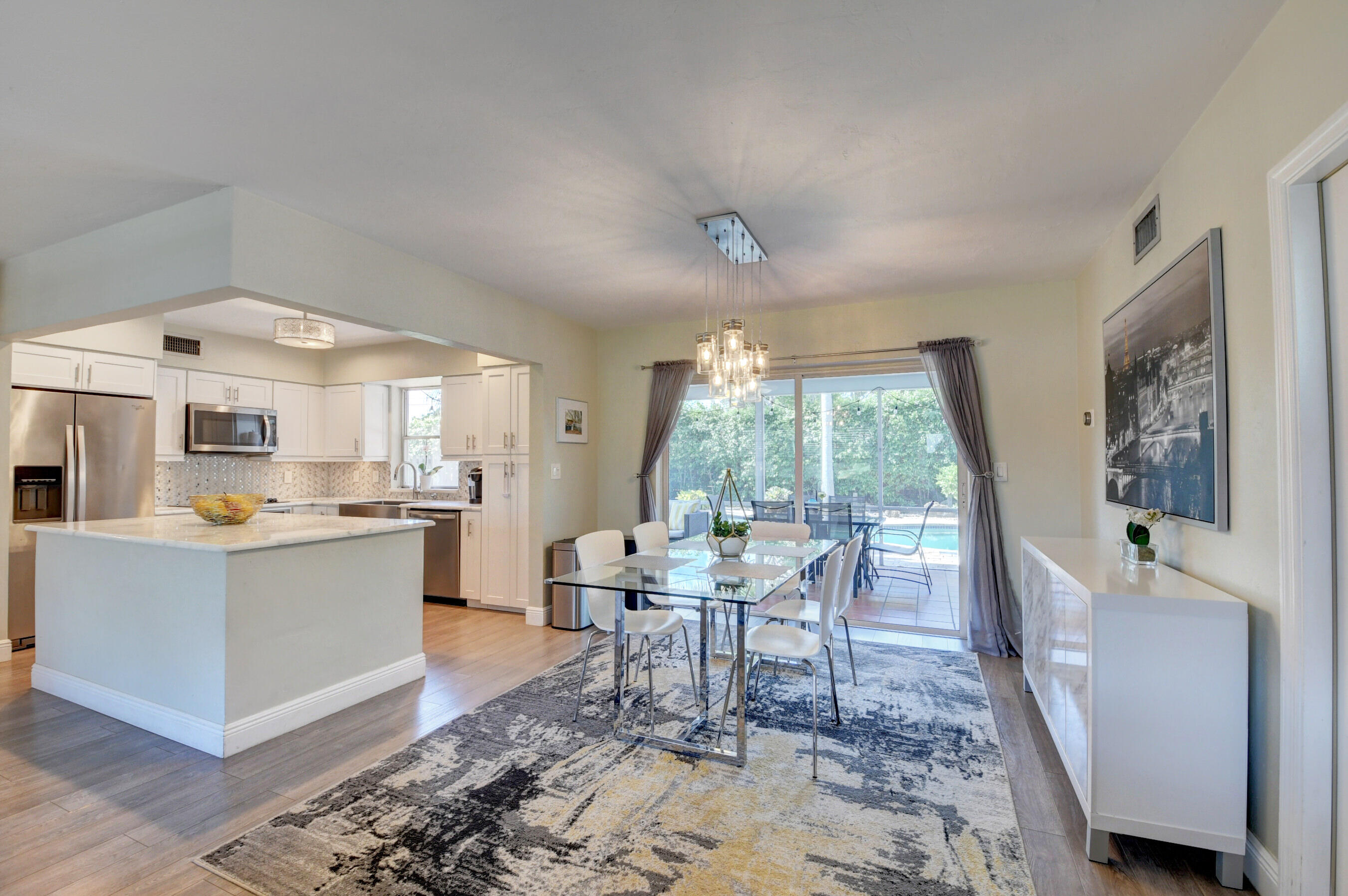 956 Southwest 4th Street Boca Raton, FL 33486 - Photo 11 of 52 a dining room with wooden floor and a floor to ceiling window
