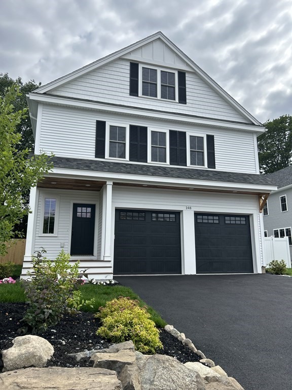 148 Main Street Waltham, MA 02453 - Photo 1 of 42 a front view of a house with a yard and garage