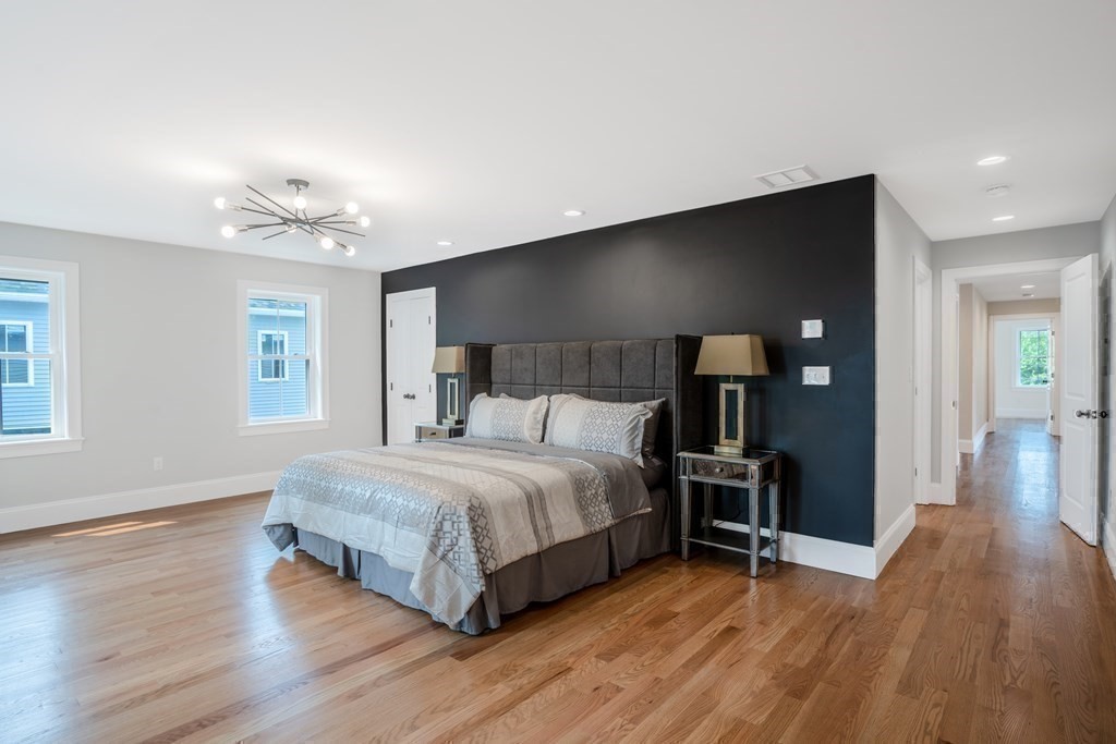 148 Main Street Waltham, MA 02453 - Photo 19 of 42 a spacious bedroom with a bed and a wooden floor