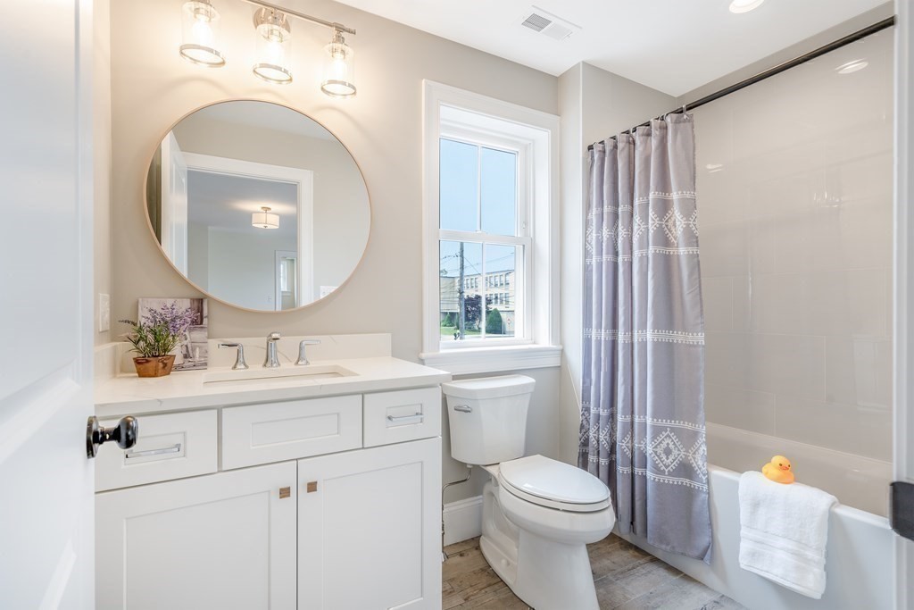 148 Main Street Waltham, MA 02453 - Photo 34 of 42 a bathroom with a toilet a sink and a mirror