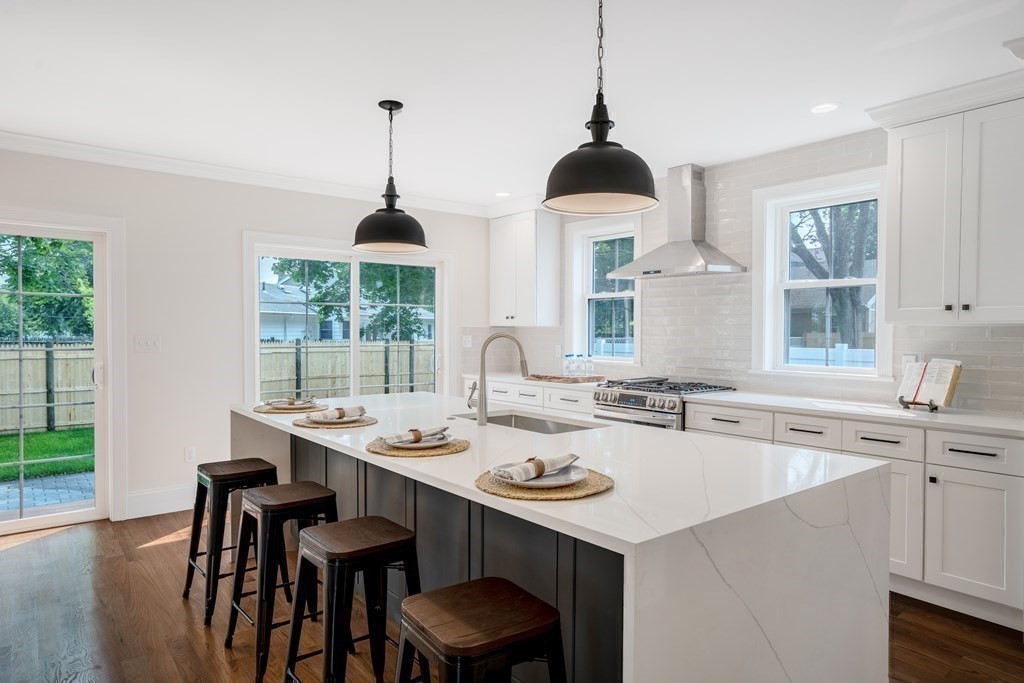 148 Main Street Waltham, MA 02453 - Photo 7 of 42 a kitchen with a dining table chairs and white cabinets
