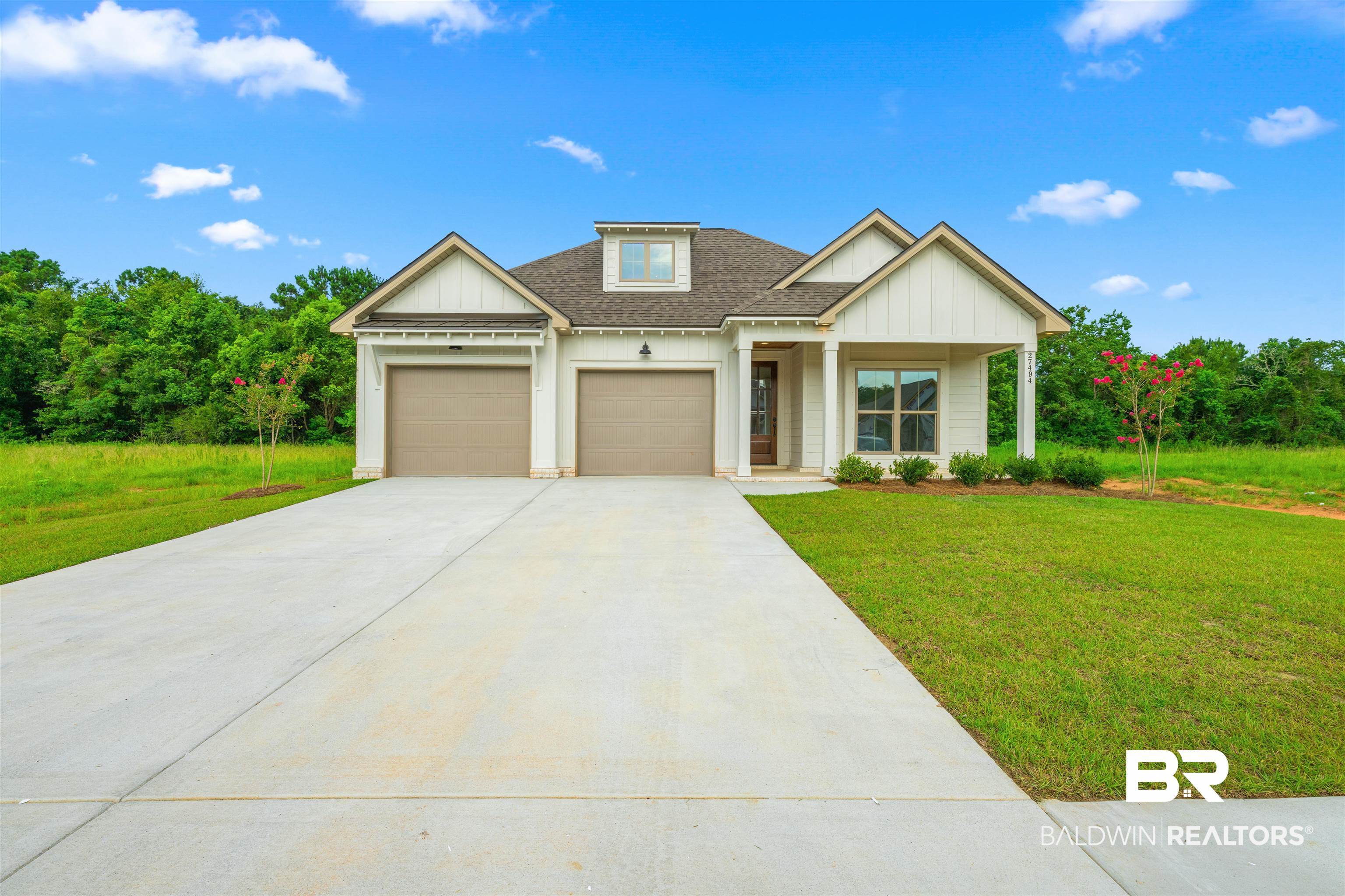 27494 Patch Pl Loop Daphne, AL 36526 - Photo 1 of 26 Contemporary farmhouse-style residence with white vertical siding and dark trim accents