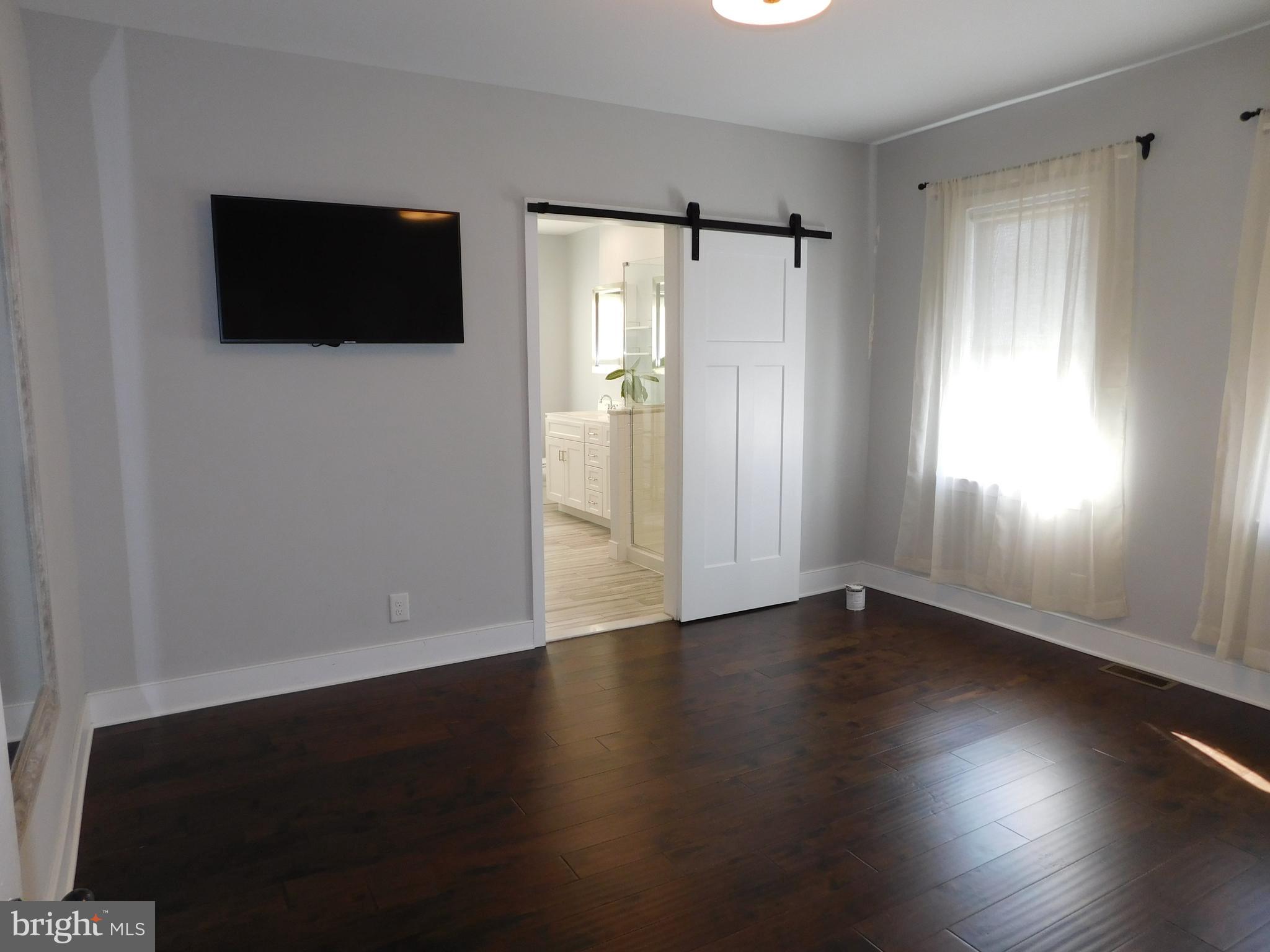 234 Crafton Avenue Pitman, NJ 08071 - Photo 26 of 61 a view of an empty room with wooden floor and a window