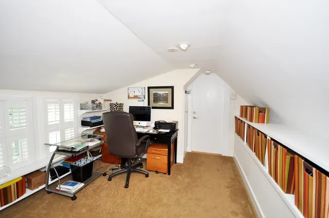 a view of a workspace with furniture and a window