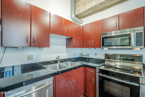 a kitchen with stainless steel appliances granite countertop a stove and a microwave