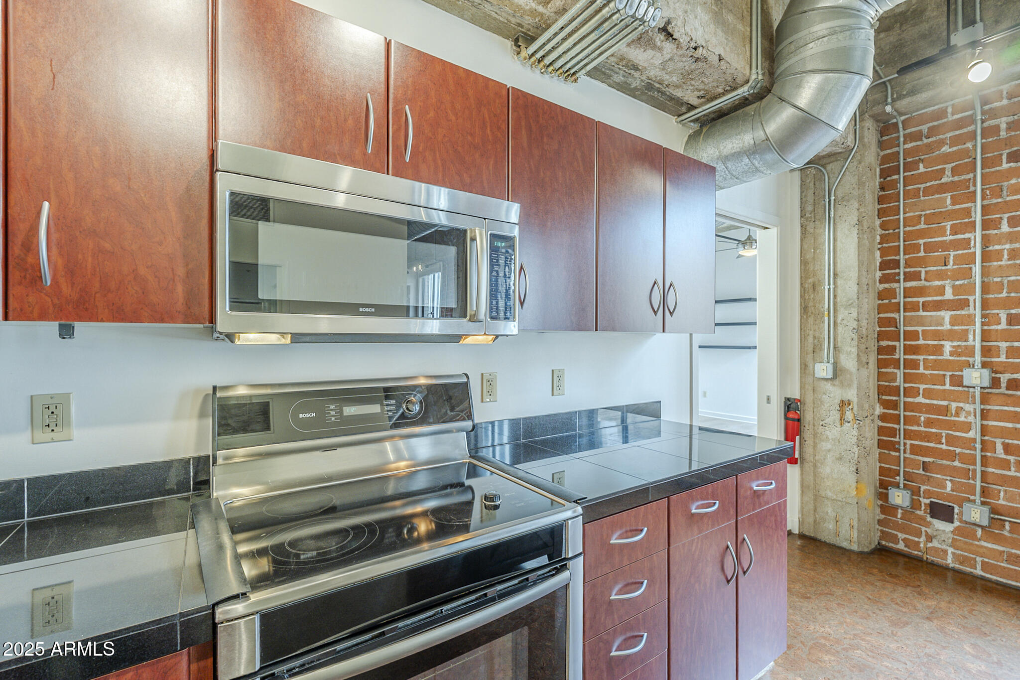 114 West Adams Street, Unit 1007 Phoenix, AZ 85003 - Photo 13 of 51 a kitchen with stainless steel appliances granite countertop a stove and a microwave