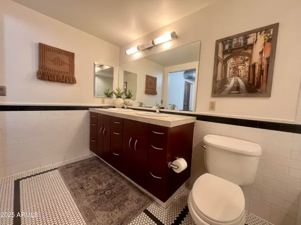 a bathroom with a granite countertop sink toilet mirror and shower