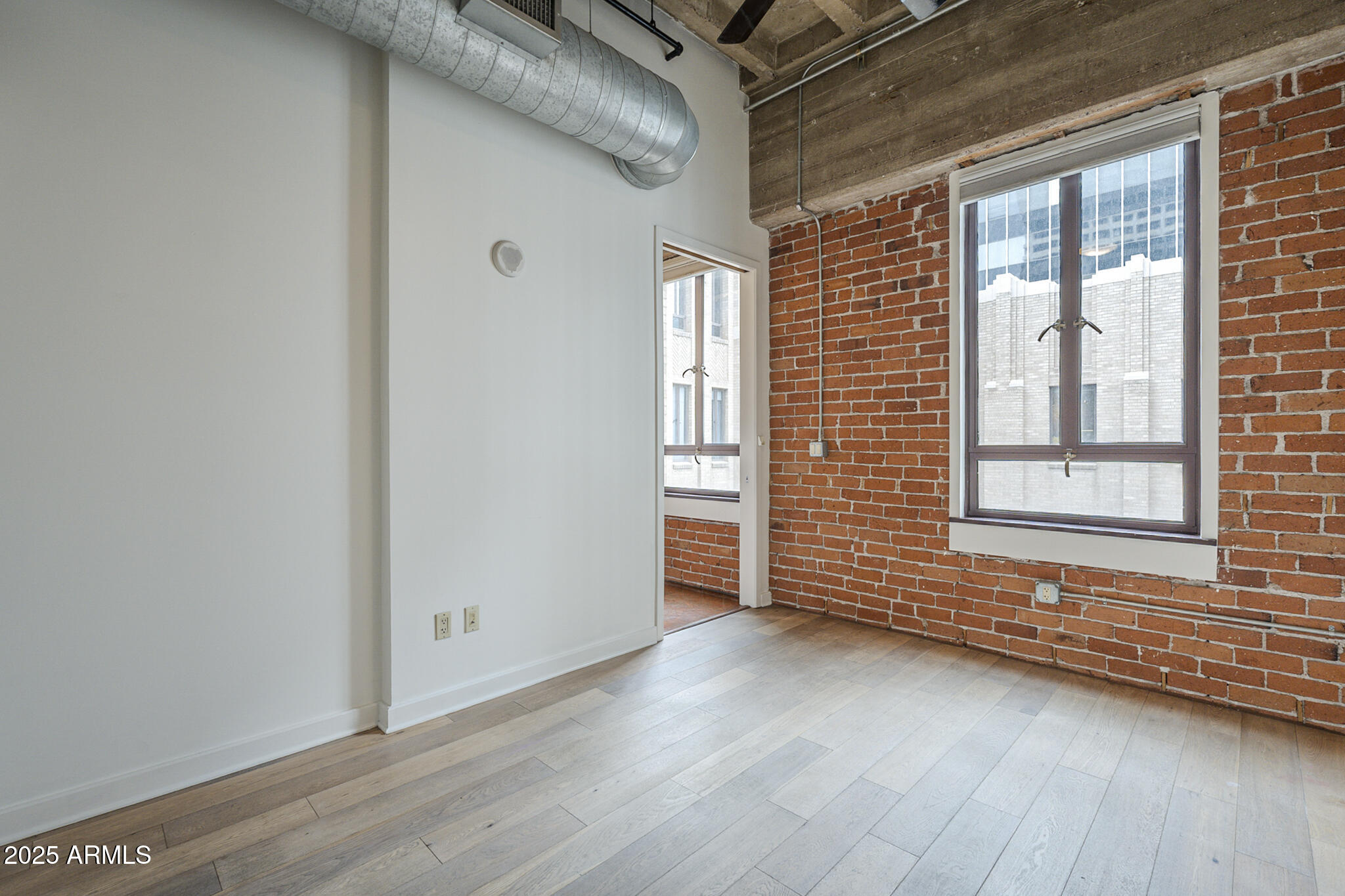 114 West Adams Street, Unit 1007 Phoenix, AZ 85003 - Photo 26 of 51 a view of an empty room with wooden floor and a window