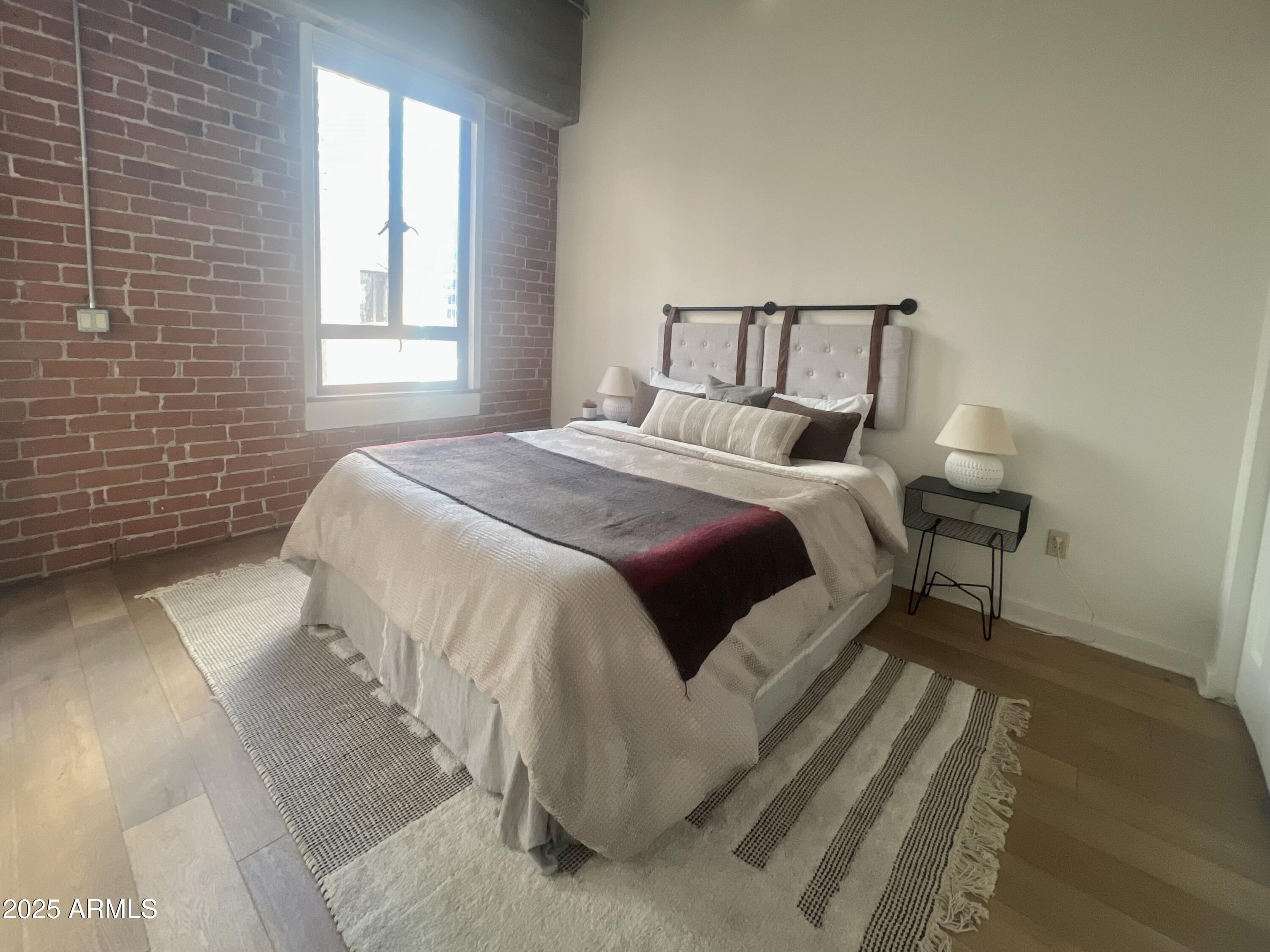 114 West Adams Street, Unit 1007 Phoenix, AZ 85003 - Photo 29 of 51 a bedroom with a bed and a window