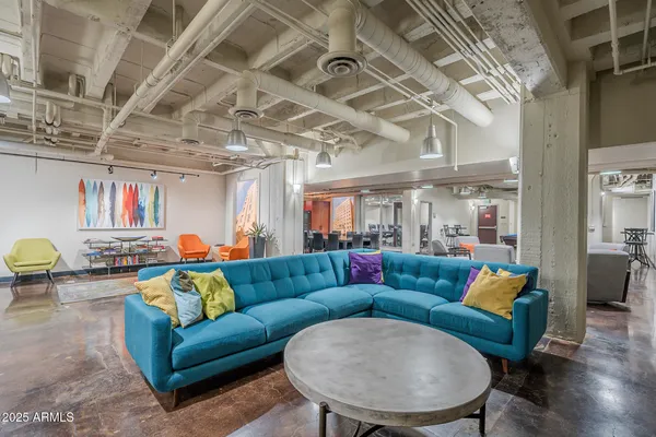 a living room with blue lights furniture and a chandelier
