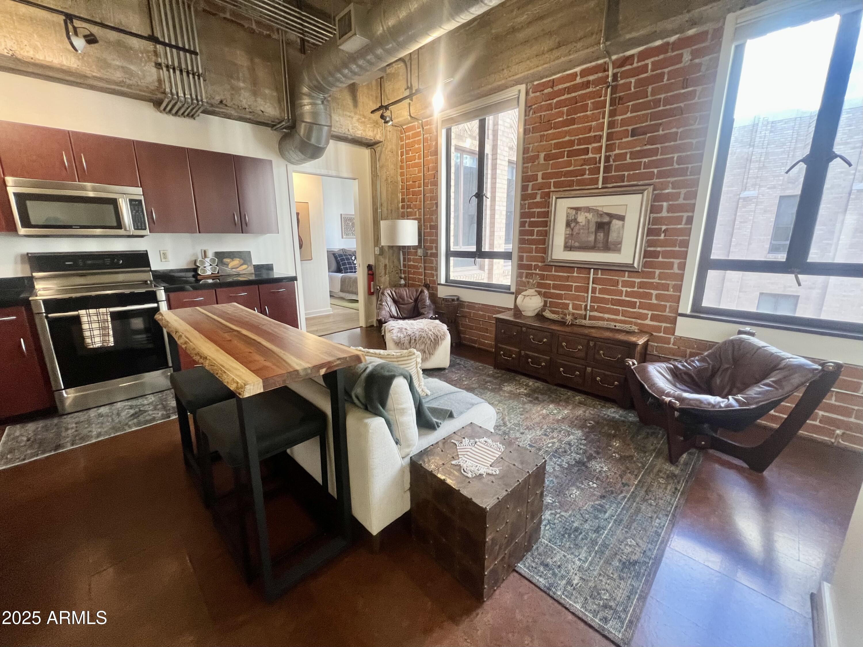 114 West Adams Street, Unit 1007 Phoenix, AZ 85003 - Photo 7 of 51 a kitchen with a table chairs sink and refrigerator