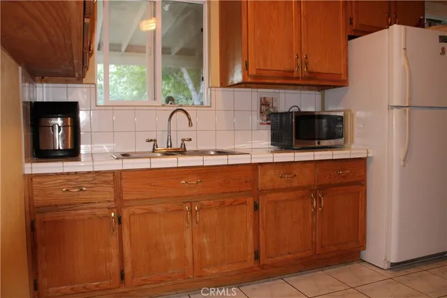 a kitchen with granite countertop a refrigerator and a sink