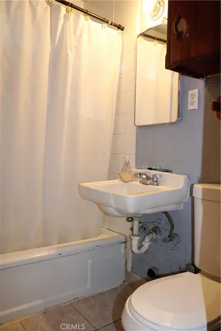a bathroom with a sink a toilet and shower curtain
