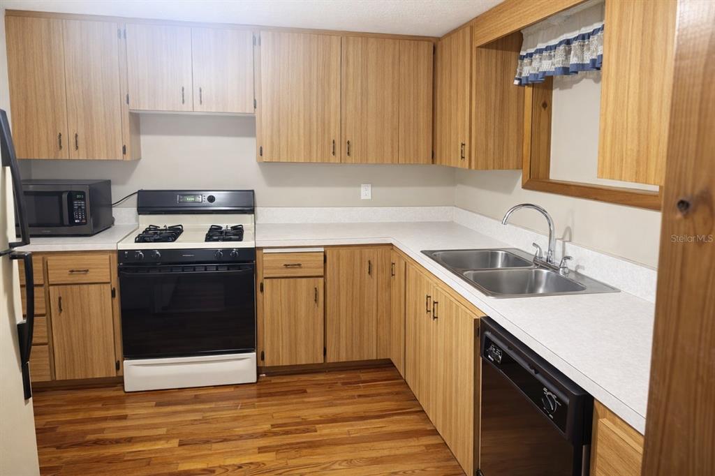 10019 Curley Road San Antonio, FL 33576 - Photo 5 of 10 a kitchen with a sink stove and cabinets