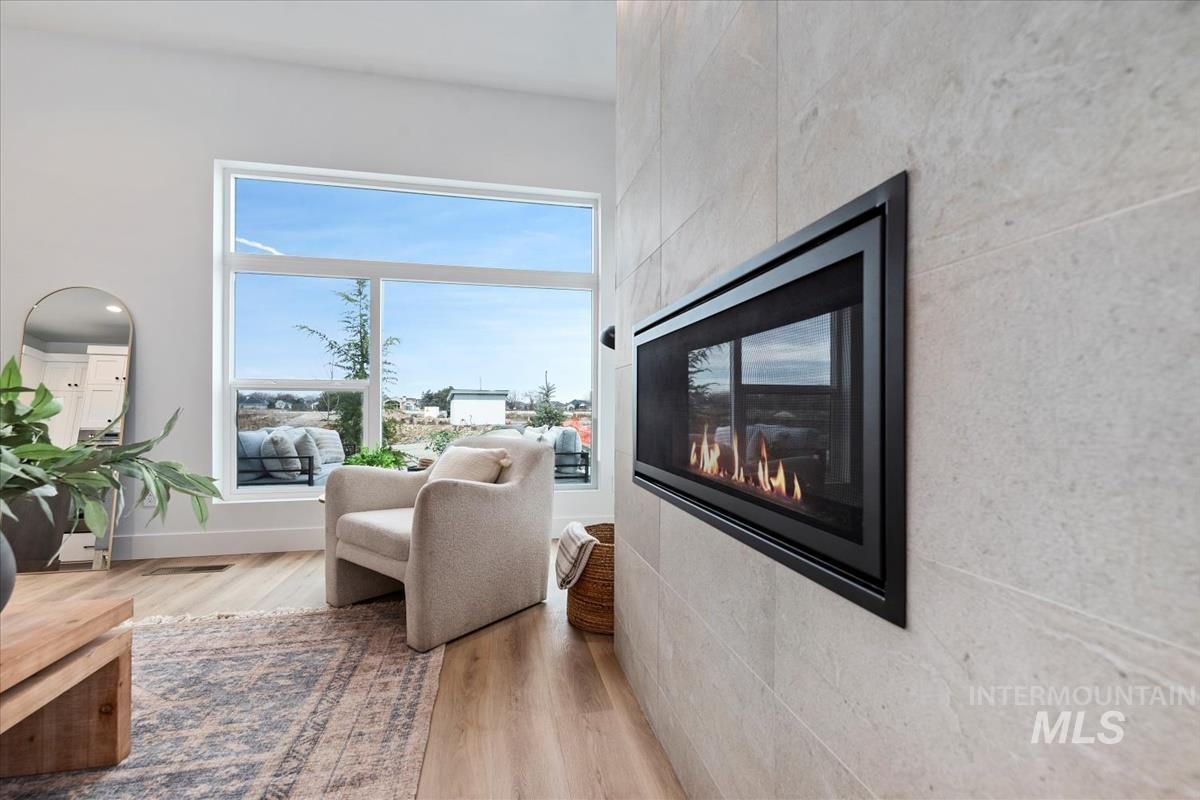 735 South Calhoun Lane Star, ID 83669 - Photo 10 of 47 Sitting room with light wood finished floors and a multi sided fireplace