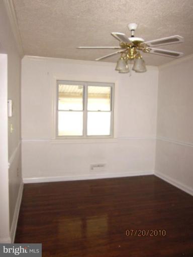 2033 Ormand Road Dundalk, MD 21222 - Photo 8 of 11 an empty room with wooden floor fan and windows