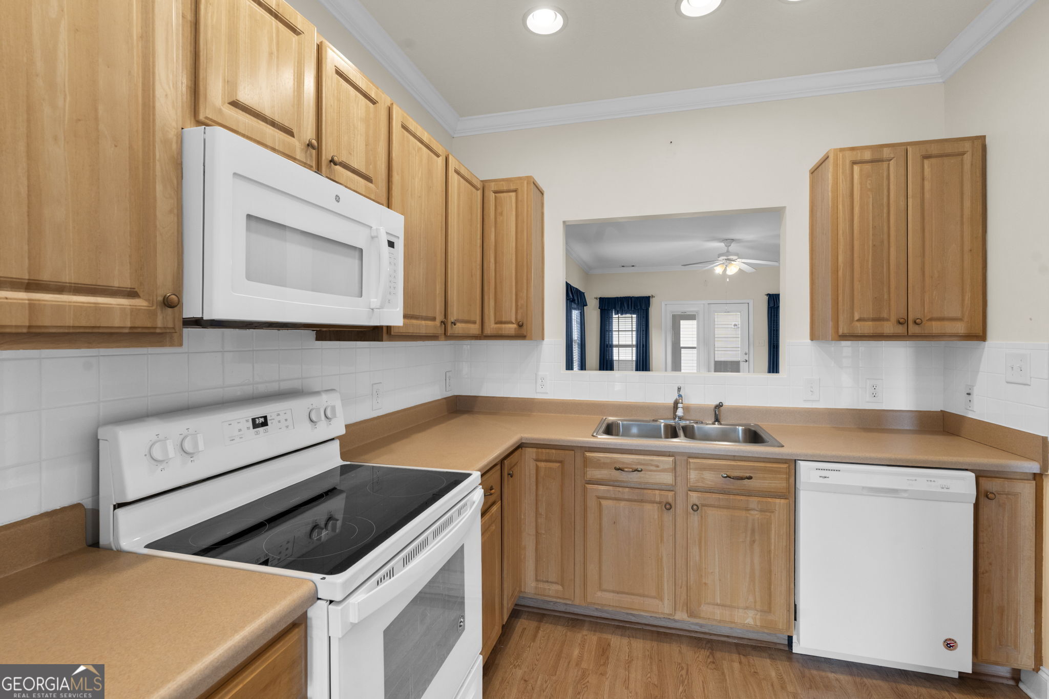 310 Pebble Beach Drive Perry, GA 31069 - Photo 7 of 42 a kitchen with stainless steel appliances granite countertop a sink and cabinets with wooden floor