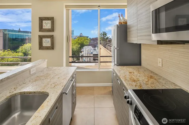 a kitchen with stainless steel appliances granite countertop a sink and a microwave