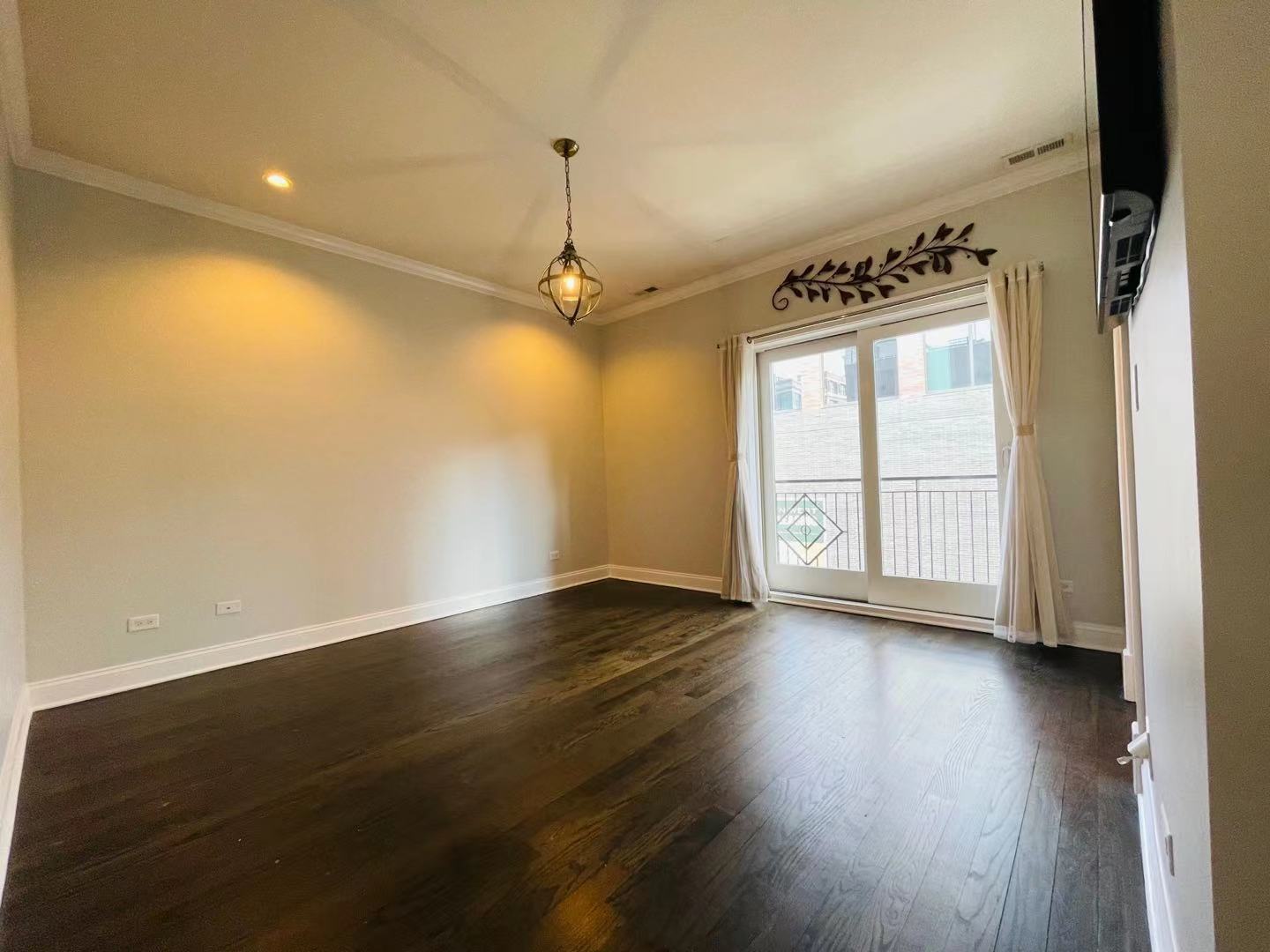 39 North Morgan Street, Unit 3 Chicago, IL 60607 - Photo 9 of 17 an empty room with wooden floor and windows