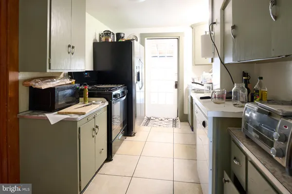 a kitchen with a stove top oven and refrigerator