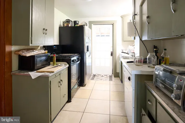 a kitchen with a stove top oven and refrigerator