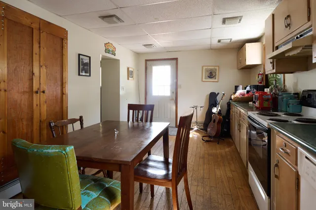 a kitchen with a dining table chairs and a refrigerator