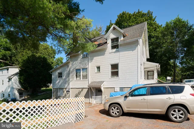 a car parked in front of a white house