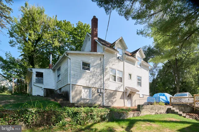 a view of a white house with a yard and plants