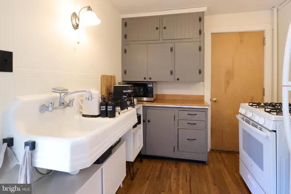a kitchen with white cabinets and sink