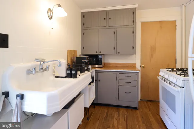 a kitchen with white cabinets and sink