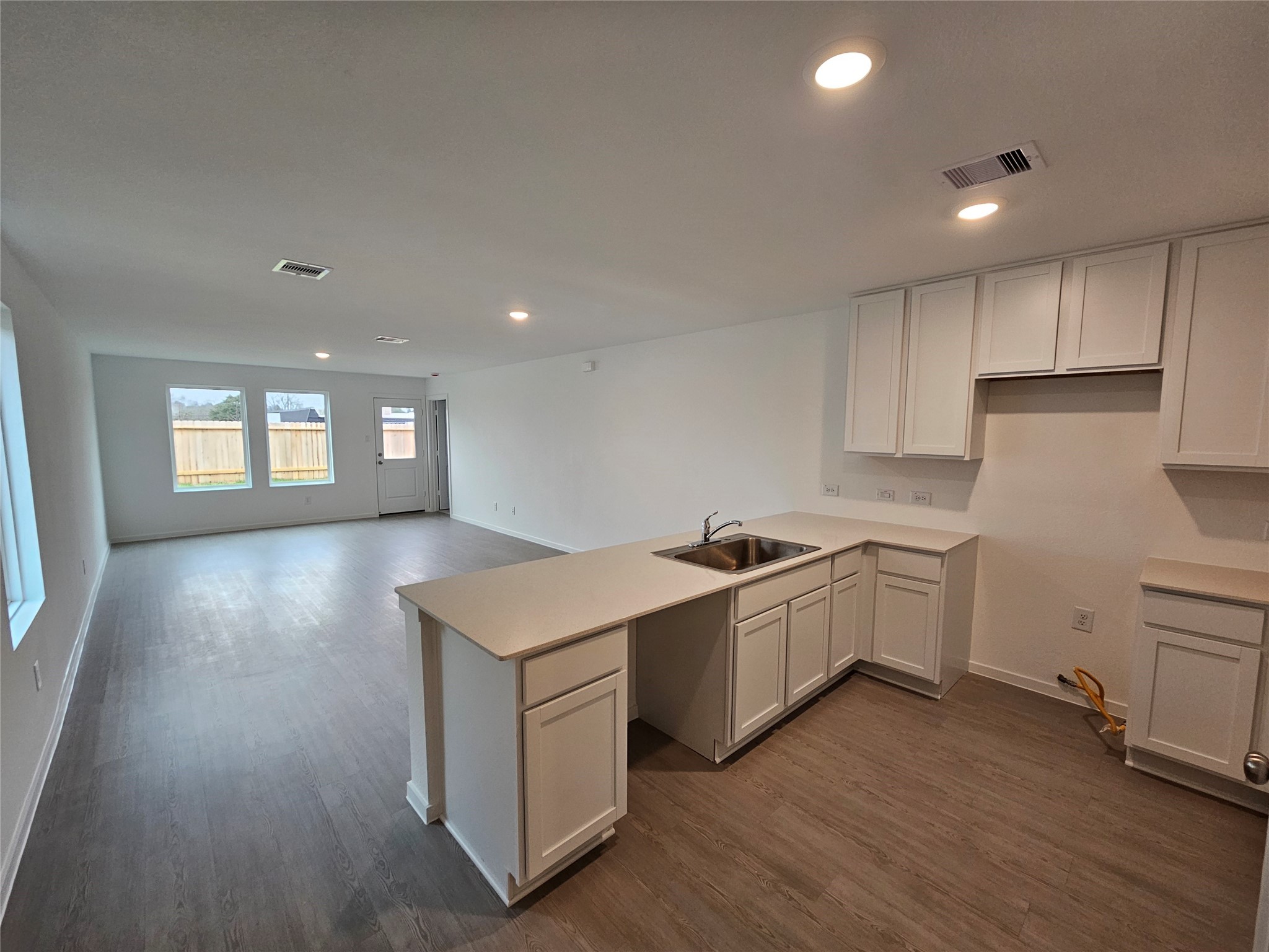 1306 Charlotte Way Wharton, TX 77488 - Photo 4 of 16 a kitchen that has a lot of cabinets in it and wooden floors