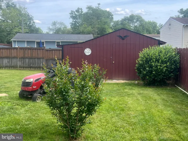 a view of a yard with a table and chair under an umbrella