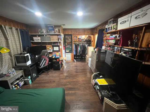 a bedroom with a bed and a flat tv screen on the dresser