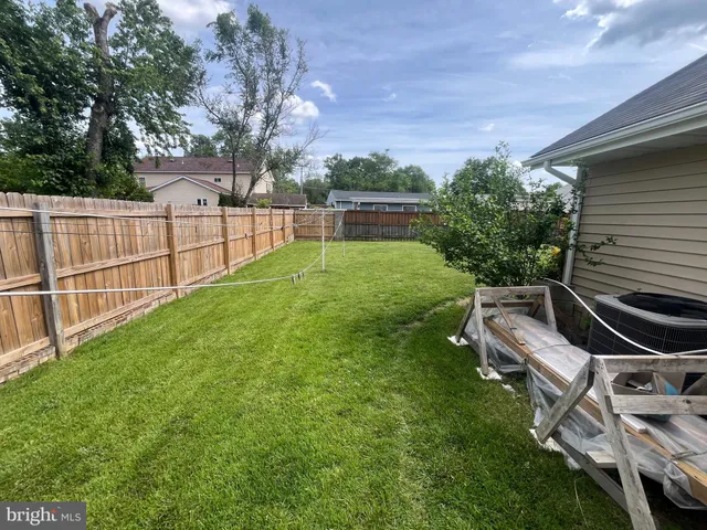 a view of a backyard with couches plants and large trees
