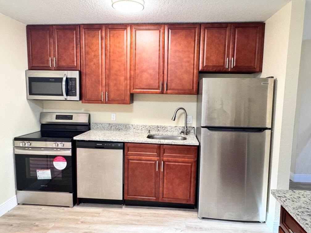 a kitchen with a refrigerator sink and microwave
