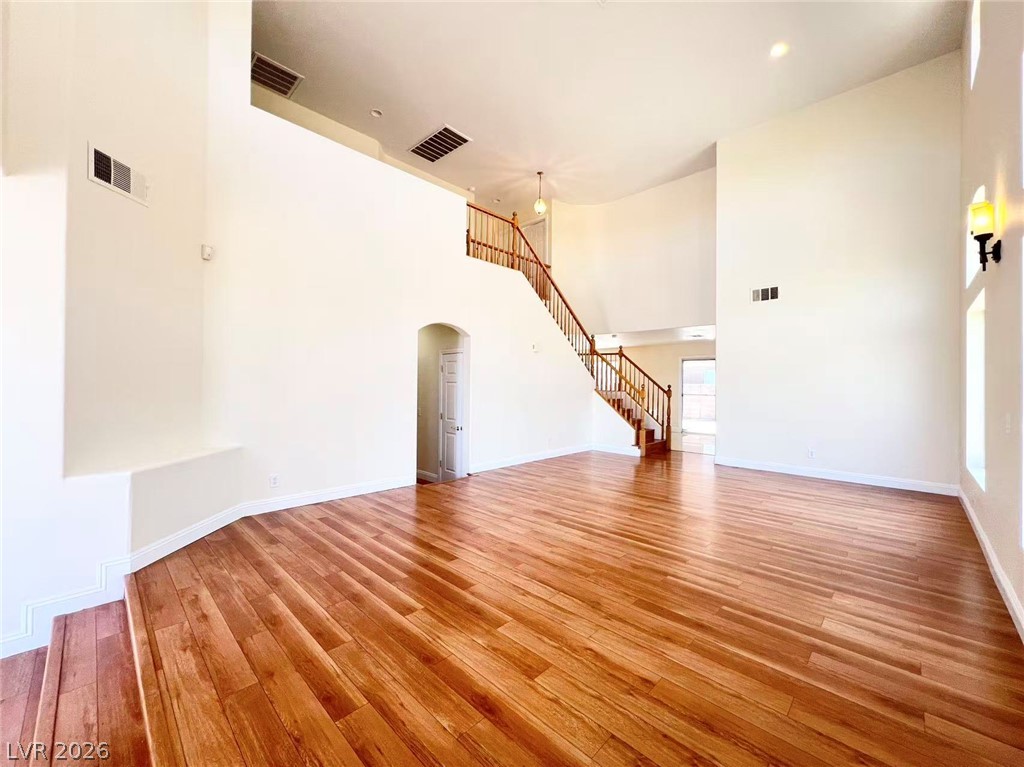9891 Ridge Hill Avenue Las Vegas, NV 89147 - Photo 5 of 29 Elegant hardwood flooring throughout complements the grand staircase in this airy living space.
