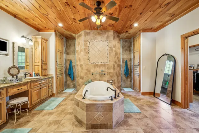 a spacious bathroom with a sink a mirror a bathtub and shower