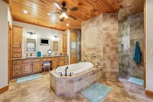 a spacious bathroom with a tub shower and mirror