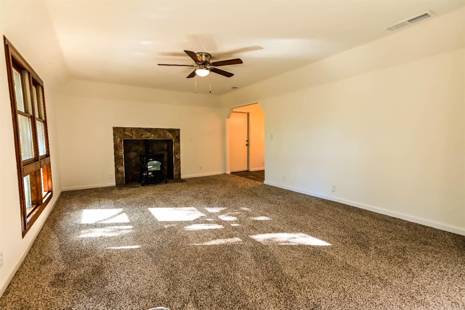31838 Comanche Road Coarsegold, CA 93614 - Photo 6 of 19 a view of an empty room with a fireplace and a window