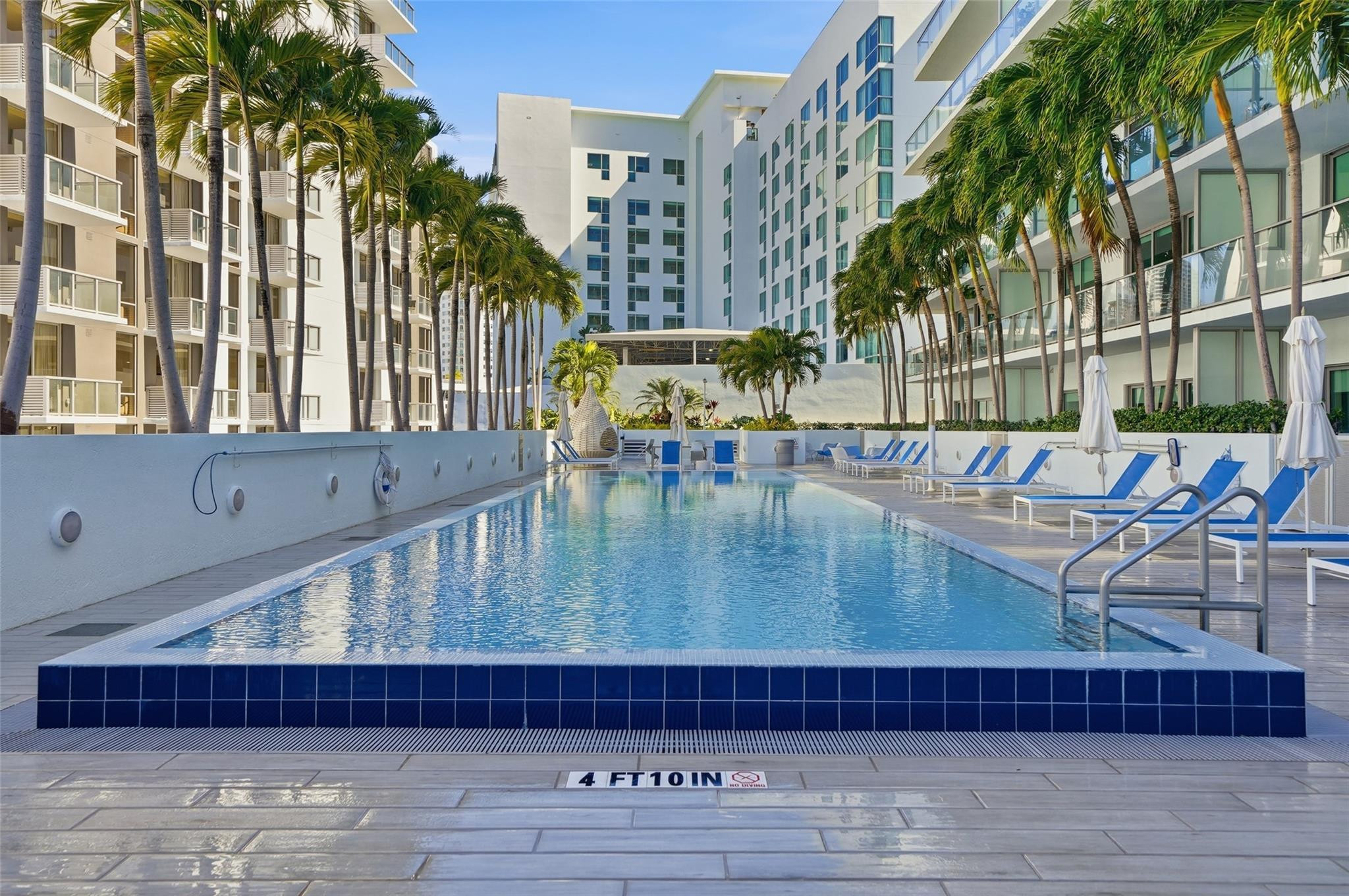 1600 Southwest 1st Avenue, Unit 510 Miami, FL 33129 - Photo 54 of 75 a view of a swimming pool with a couches chairs and wooden floor