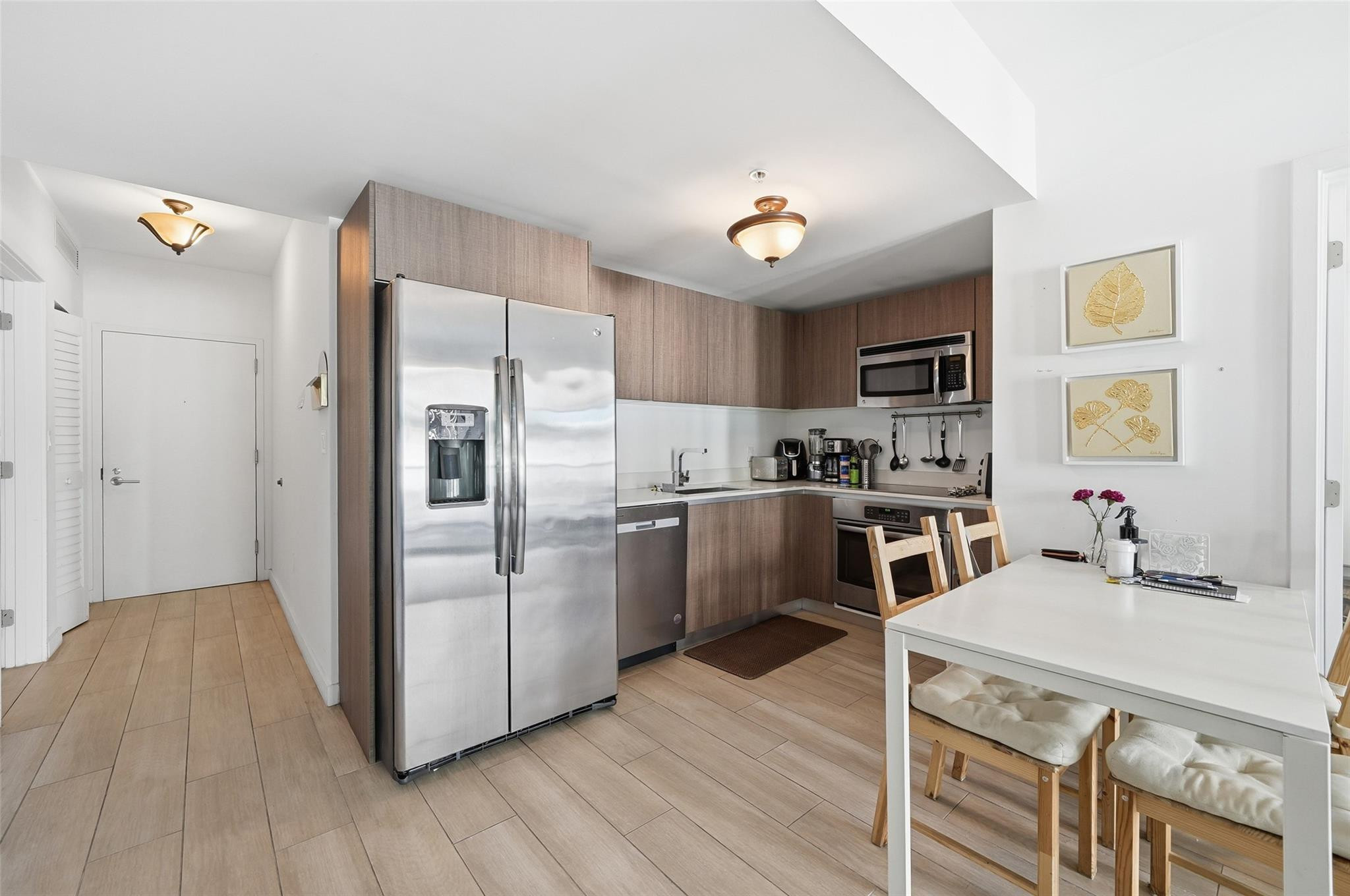 1600 Southwest 1st Avenue, Unit 510 Miami, FL 33129 - Photo 9 of 75 a kitchen with a refrigerator a sink dishwasher and a stove with wooden floor