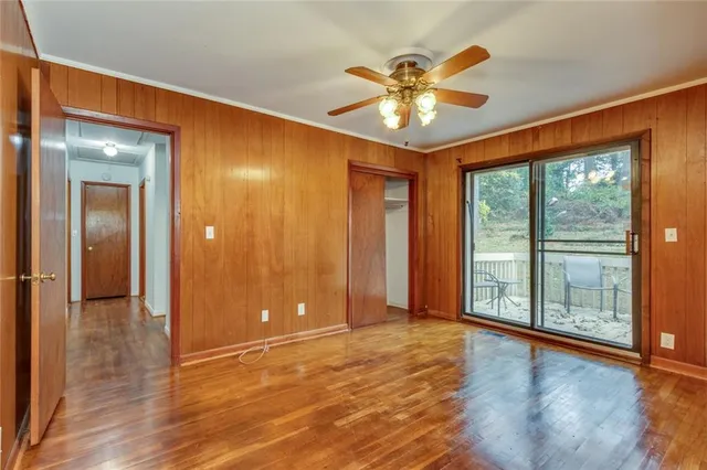a view of an empty room with a window and wooden floor