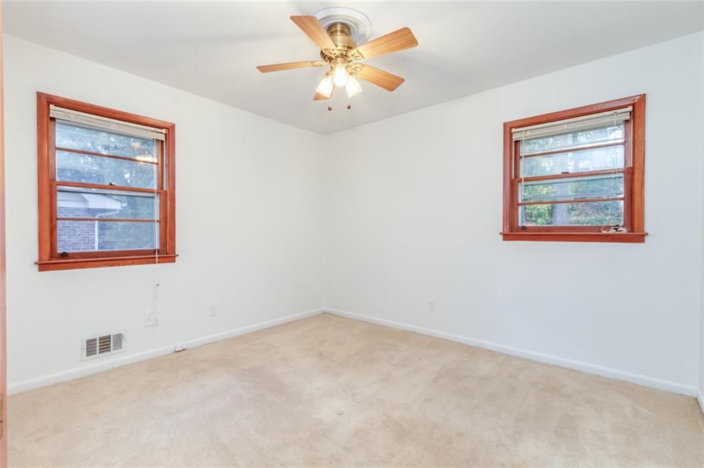 4424 Locksley Road Tucker, GA 30084 - Photo 27 of 50 an empty room with a window and a ceiling fan
