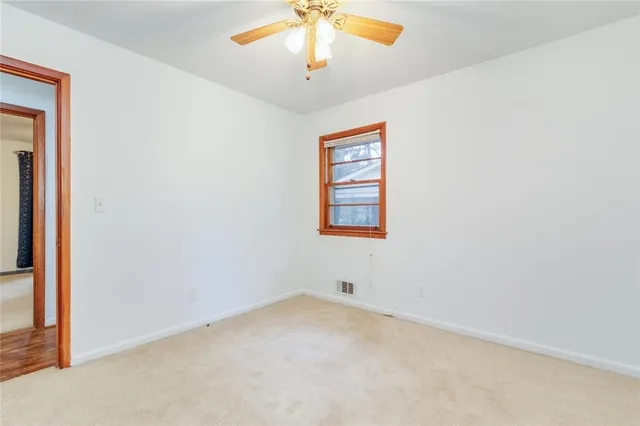 an empty room with a chandelier fan