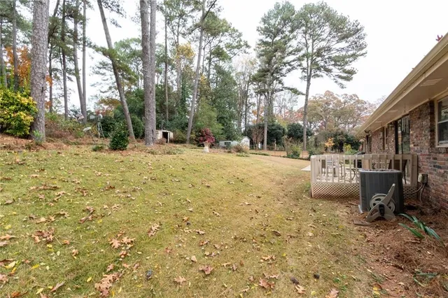 a view of a house with a wooden deck and furniture