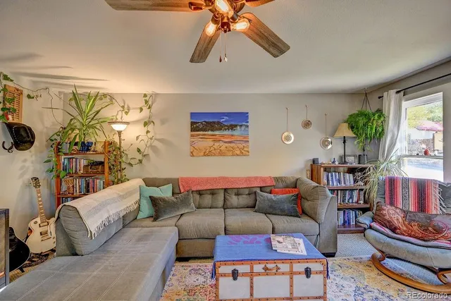 a living room with furniture a rug and a window