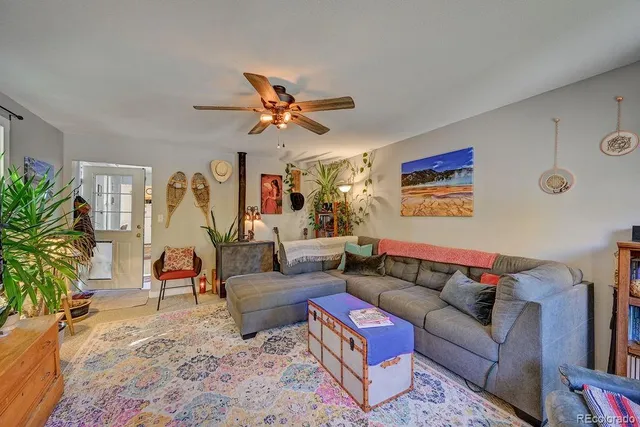 a living room with furniture ceiling fan and a rug