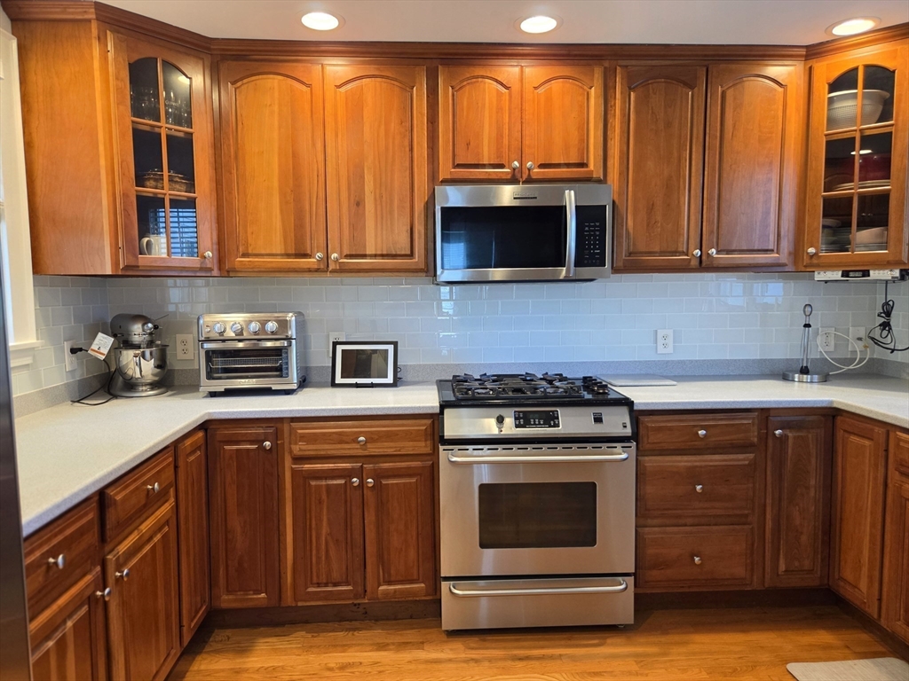 25 Waldeck Road Milton, MA 02186 - Photo 10 of 34 a kitchen with stainless steel appliances granite countertop a stove a sink and a microwave
